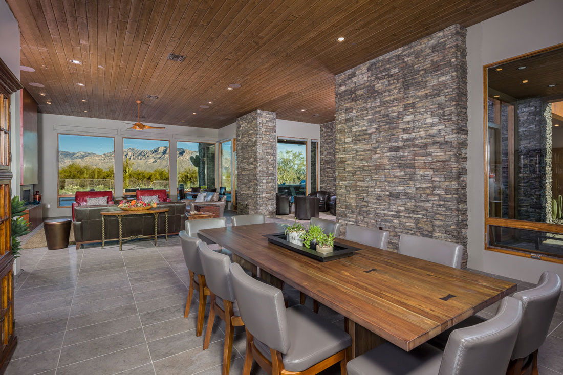 Beautiful open living and dining area with warmly contrasting textures of wood and sto