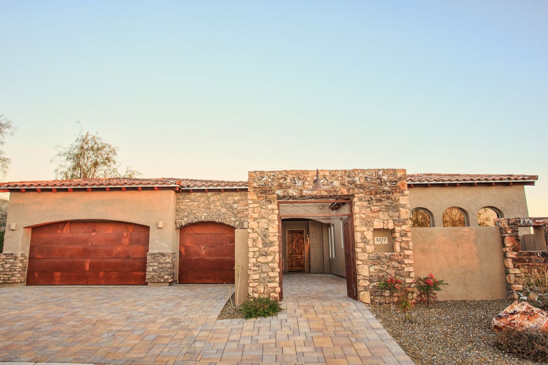 Dove model with front courtyard featuring stone entry and etched steel garage doors
